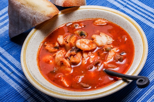 Delisious fisherman stew with bread on plate