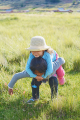 Naklejka na ściany i meble Native american girl holding her little sister in the countryside.