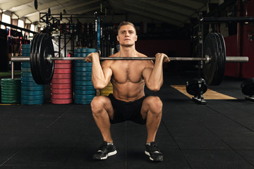 Fototapeta na wymiar Muscular man during his weightlifting workout in the gym