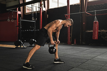 Sportsman doing exercises with a kettlebell in the gym