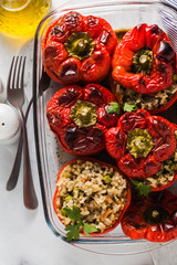 ready baked stuffed peppers in a glass baking dish on white marble table. healthy vegan cuisine for the whole family. comfort food