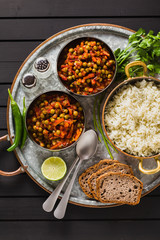 vegan curry with green peas and basmati rice served on a wooden table tray, healthy Indian comfort food
