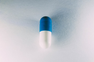 Pill white and blue close up. Capsule medication.