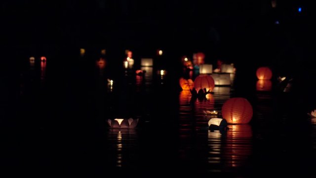 Festival of lanterns on the water. Water lantern in the shape of a Lotus with a candle flame floating at night on the water.