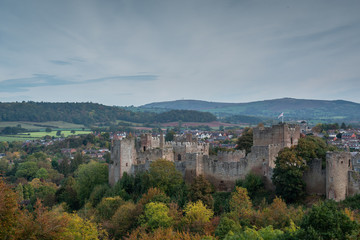 Fototapeta na wymiar View across autumnal woodland to Ludlow Castle built by the Normans with the Clee Hills in the background.