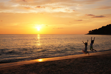 Fototapeta na wymiar Gorgeous sunset with a jumping couple.