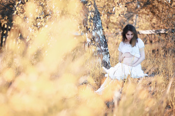 Fototapeta na wymiar Pregnant woman in nature for a walk in the autumn