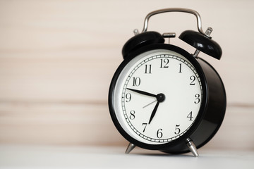 Vintage alarm clock is on a bedside table