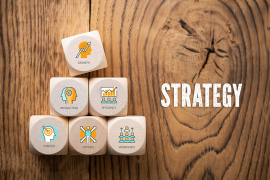 Cubes with symbols and the word "strategy" on wooden background