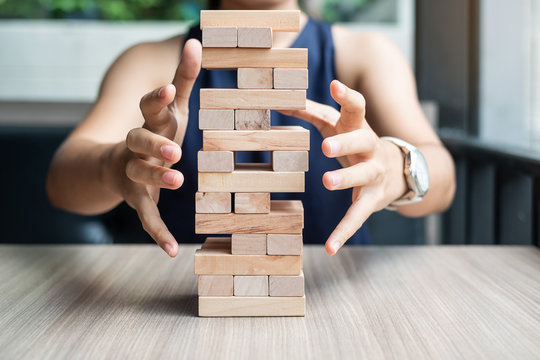 Businesswoman hand cover  wooden block on the tower. Business planning, Risk Management, Solution and strategy Concepts