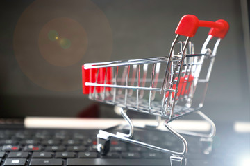Collection of shopping cart full of shopping time.Side view of the laptop keyboard and shoping...