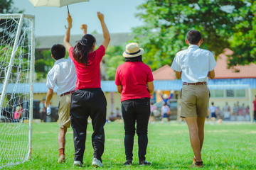 Female Teachaer is coaching children training In soccer team in