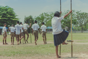 Student try to  walk on the Bamboo legs,Children playing Old tha