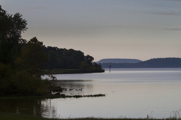 Still waters, plateau mountains, shoreline at dusk