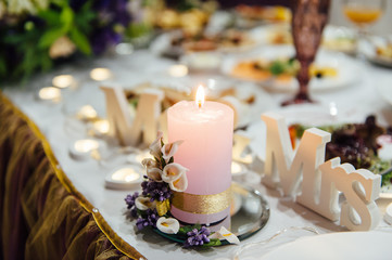 Bouquets of pink and white flowers near the candles on the table.