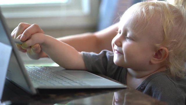 Little baby learning to use laptop computer .