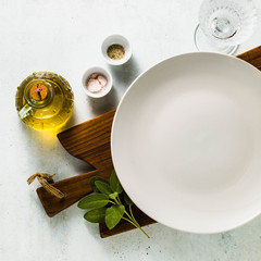 table setting. empty plates, spices, cutlery and olive oil. place to write text. copy space. collage template