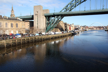 Naklejka premium The Tyne and Millenium bridges of Newcastle-Upon-Tyne with the busy sunday market taking place on the quayside