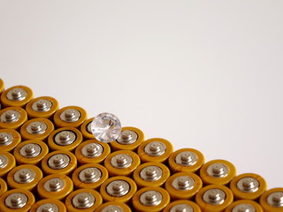 A Single Diamond Showing the Facet Cut of the Gem Stone, on a Group of Positive Battery Terminals.