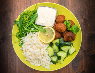 vegan dish with soymeatballs, cucumber,rice and yogurt sauce