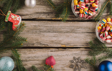 Candies, ornaments and Christmas tree branches on rustic wooden table. Top view, flat lay.