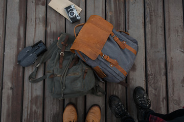Flatlay with boots, backpack, flask and retro camera