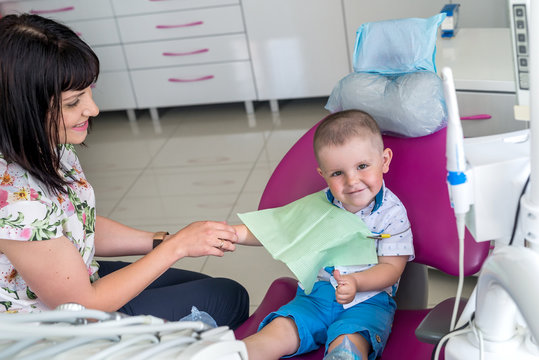 Little boy and mother expect dentist in an armchair