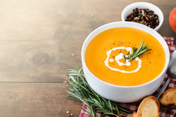Pumpkin Cream soup on wooden  background. Autumn yellow cream-soup in country style. Top view.