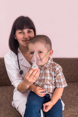 Friendly doctor doing inhalation with nebulizer to a boy