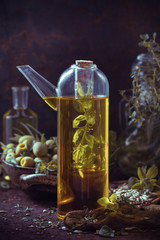 A bottle olive oil fruits branches herbs