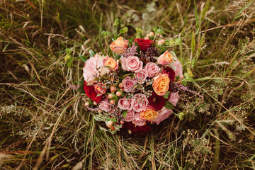 Obraz na płótnie Canvas Wedding details. wedding bouquet of various flowers on the grass