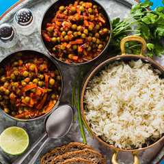 vegan curry with green peas and basmati rice served on a blue table tray, healthy Indian comfort food