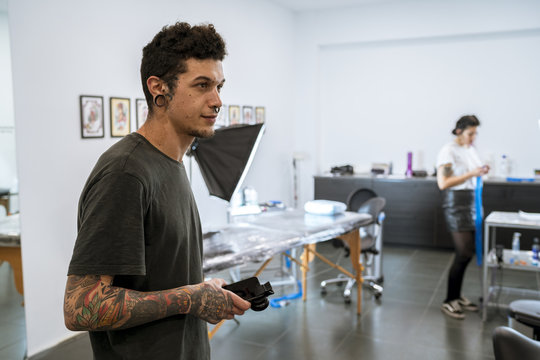 Young tattooist in his tattoo studio