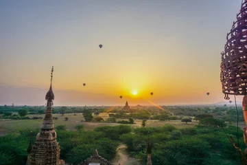 Fotobehang A beautiful sunrise with balloons floating in the air in Bagan is a city of thousands of Buddhist pagodas. Myanmar © Pavel