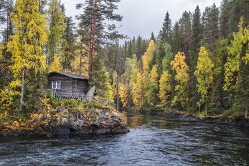 Beautiful fall colors with cabin and river at autumn day in Myllykoski, Kuusamo, Finland