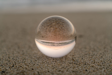 Crystal ball on the sand sunset