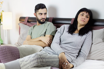 Unhappy couple in bed fighting sad