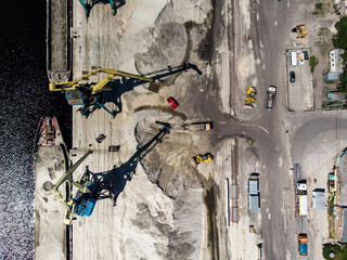 Construction cranes on river's bank by drone