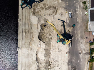 Construction cranes on river's bank by drone