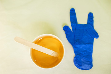 The concept of aesthetic health. Bank with sugaring, spatulas for depilation, disposable gloves