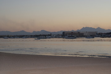 Yellow sand in Egypt Red Sea while diving to colar reefs in all inclusive vacation with background mountains