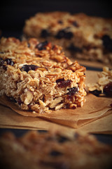 Homemade granola bars with nuts and cranberries over black background