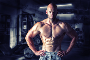 Fototapeta na wymiar Strong bodybuilder man pumping up muscles after extreme workout . Bodybuilding concept background.