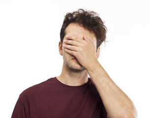 Young man blocking face with hands