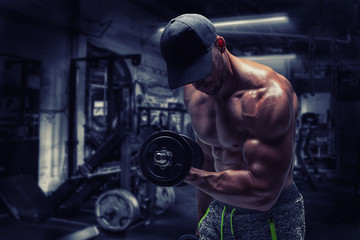 Strong bodybuilder man pumping up muscles after extreme workout . Bodybuilding concept background.