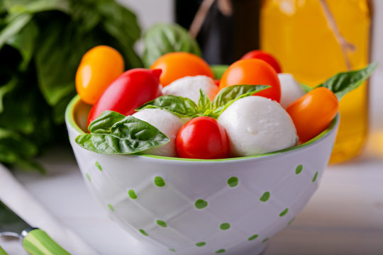 Italian capresse salad with basil , tomatoes  and mozzarella . Close up