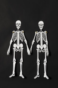 Paper skeletons against black background. Paper skeletons for Halloween decoration against black background