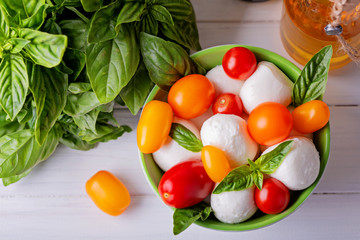 Ingredients for Italian caprese - mozzarella, basil and cherry tomatoes, top view