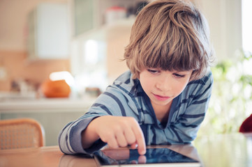 Little boy playing with digital tablet.