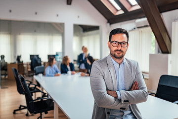 Fototapeta premium Portait of successful business executive at conference room. Employees in the background.